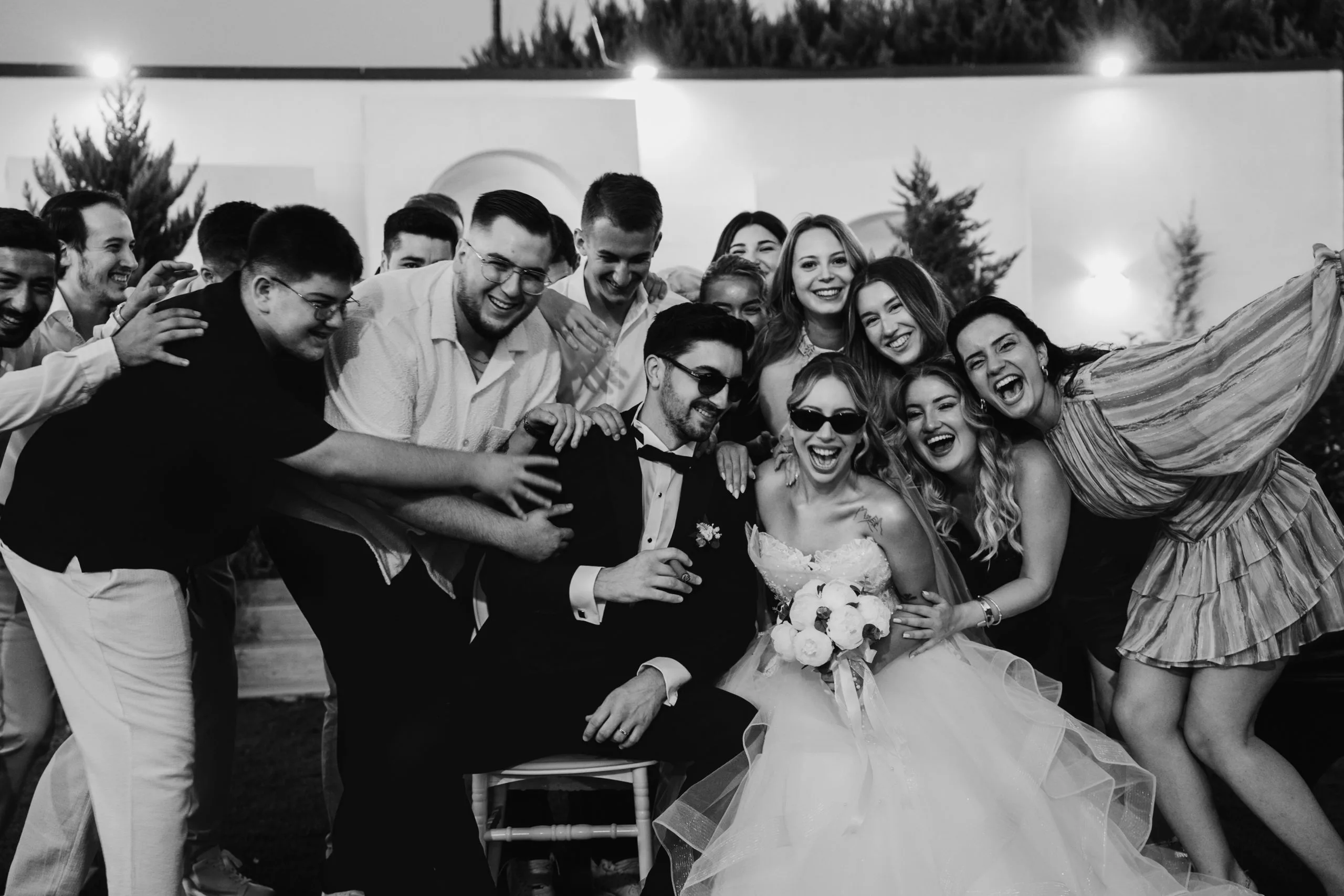 Düğün gününde çift ve arkadaşlarının neşeli grup portresi